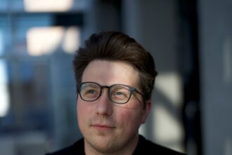 Igor Babuschkin founder of River AI standing in modern office