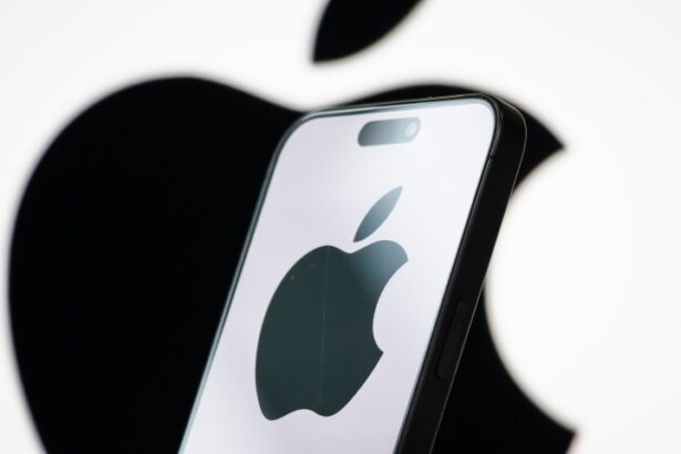 Apple logo displayed on a smartphone screen with stock market graphs in background