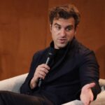 Brian Chesky, Airbnb co-founder and CEO, speaking onstage at a tech event.