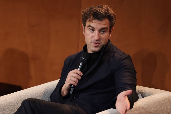 Brian Chesky, Airbnb co-founder and CEO, speaking onstage at a tech event.