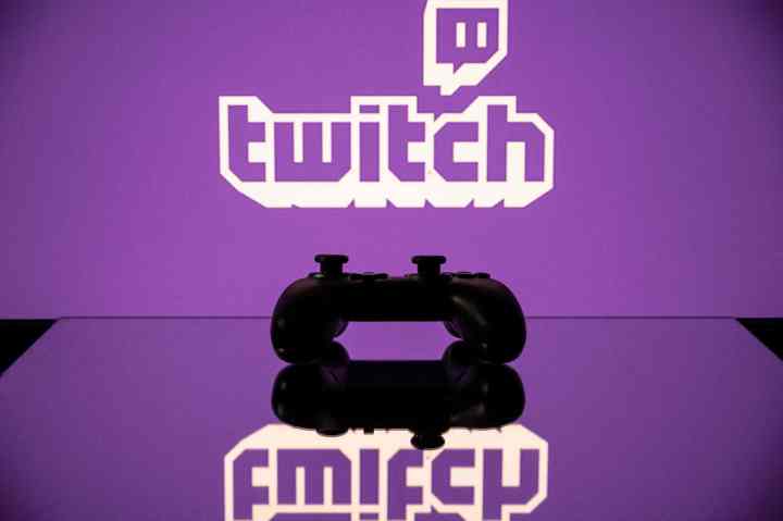 Twitch logo displayed on a computer screen with a streamer's face in the background